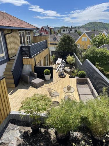 Her har vi totalforvandlet en kjedelig hage til en fantastisk uteplass med terrasser i forskjellige nivåer, utestue og spilerekkverk rundt.